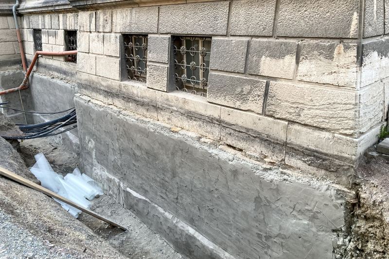 Rendered stone cellar wall prepared for a waterproof coating